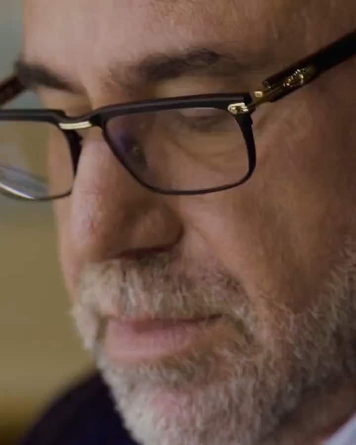 Video of Michael Gold wearing glasses, white shirt and navy blazer, transitioning to close up of molecule textures